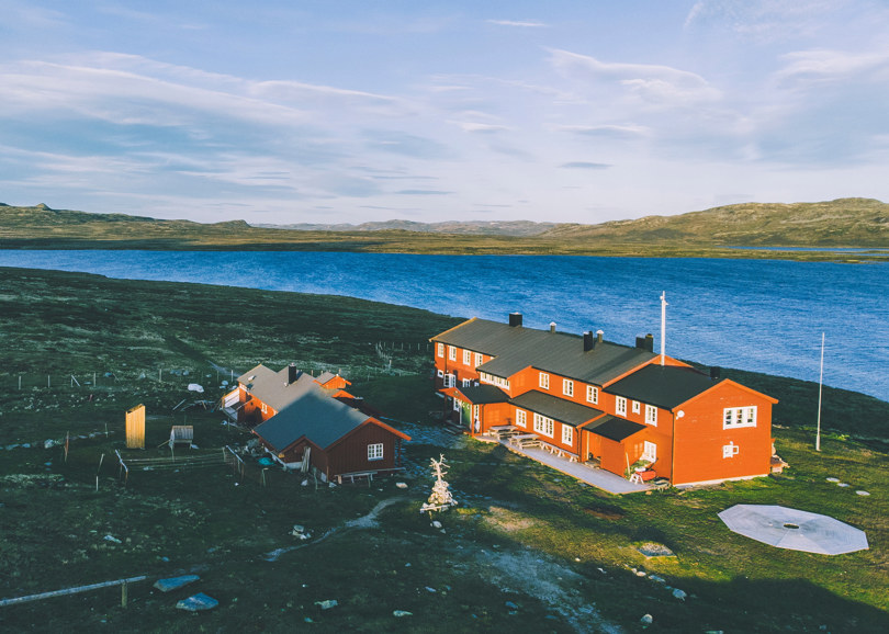 Rødmalt hytte med solceller på taket