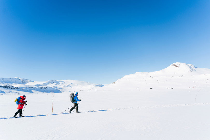 En gruppe mennesker som går på ski på snøen