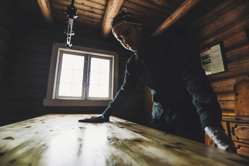 Man washing a table at a DNT cabin