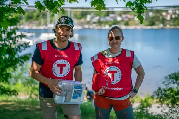 To smilende personer med rød DNT-vest.