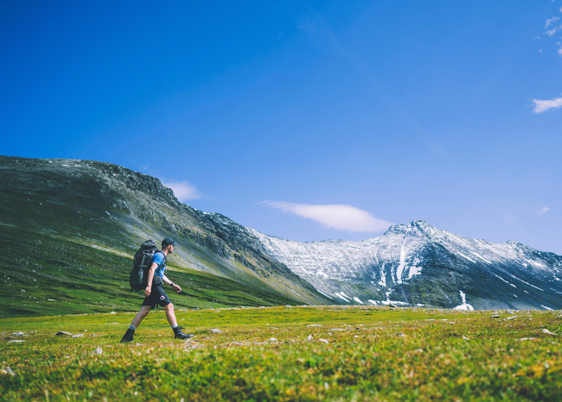 Mann går gjennom fjellheimen