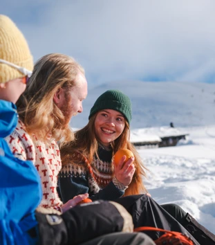 en gruppe mennesker som sitter på et snødekt fjell