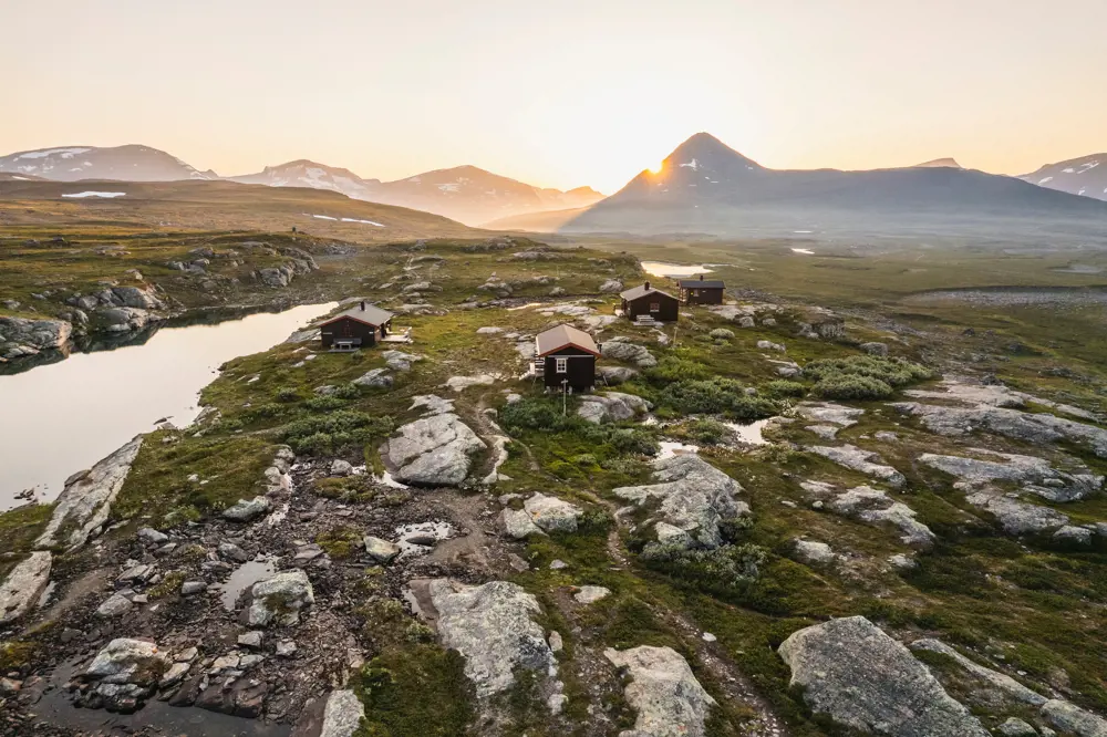 tre hytter i fjellandskap