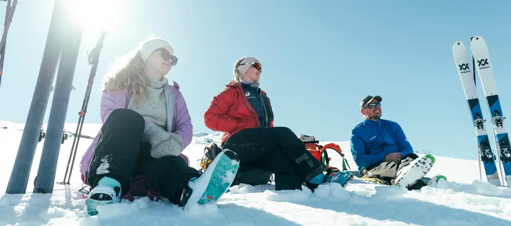 Tre personer som nyter solen i vinterfjellet