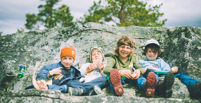4 barn som sitter på en fjellhylle
