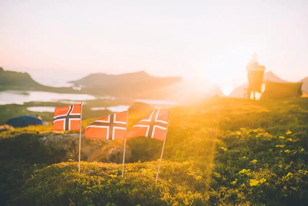 tre flagg i naturen i solnedgang