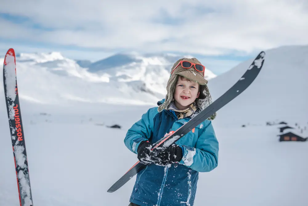 et barn i skidress i fjellandskap