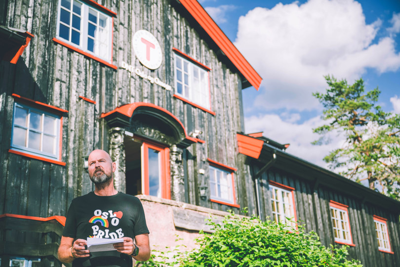 en mann som står foran en bygning med et skilt på