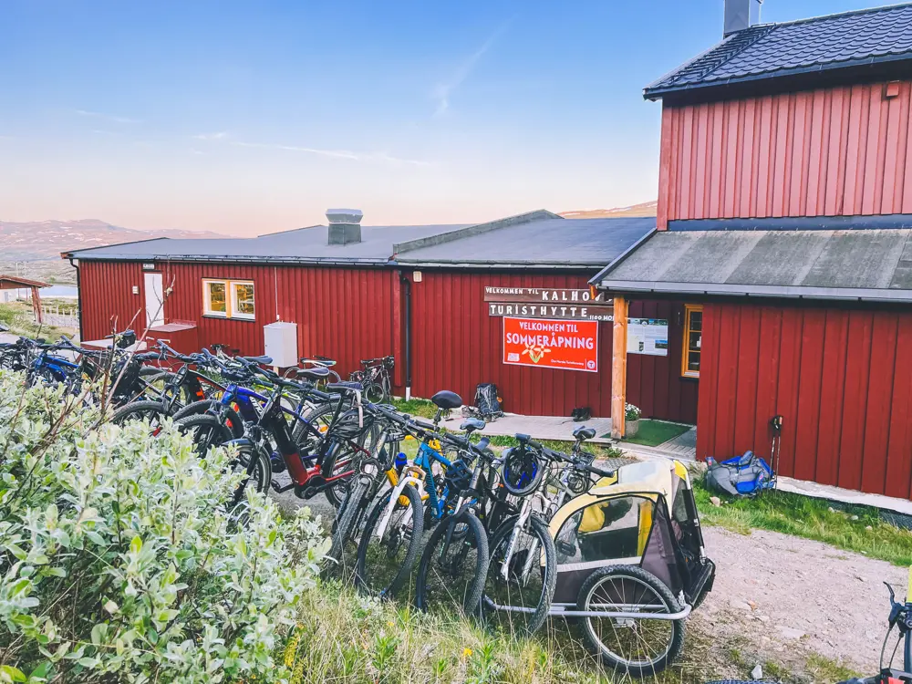 Rød hytte med mange sykler i forgrunn