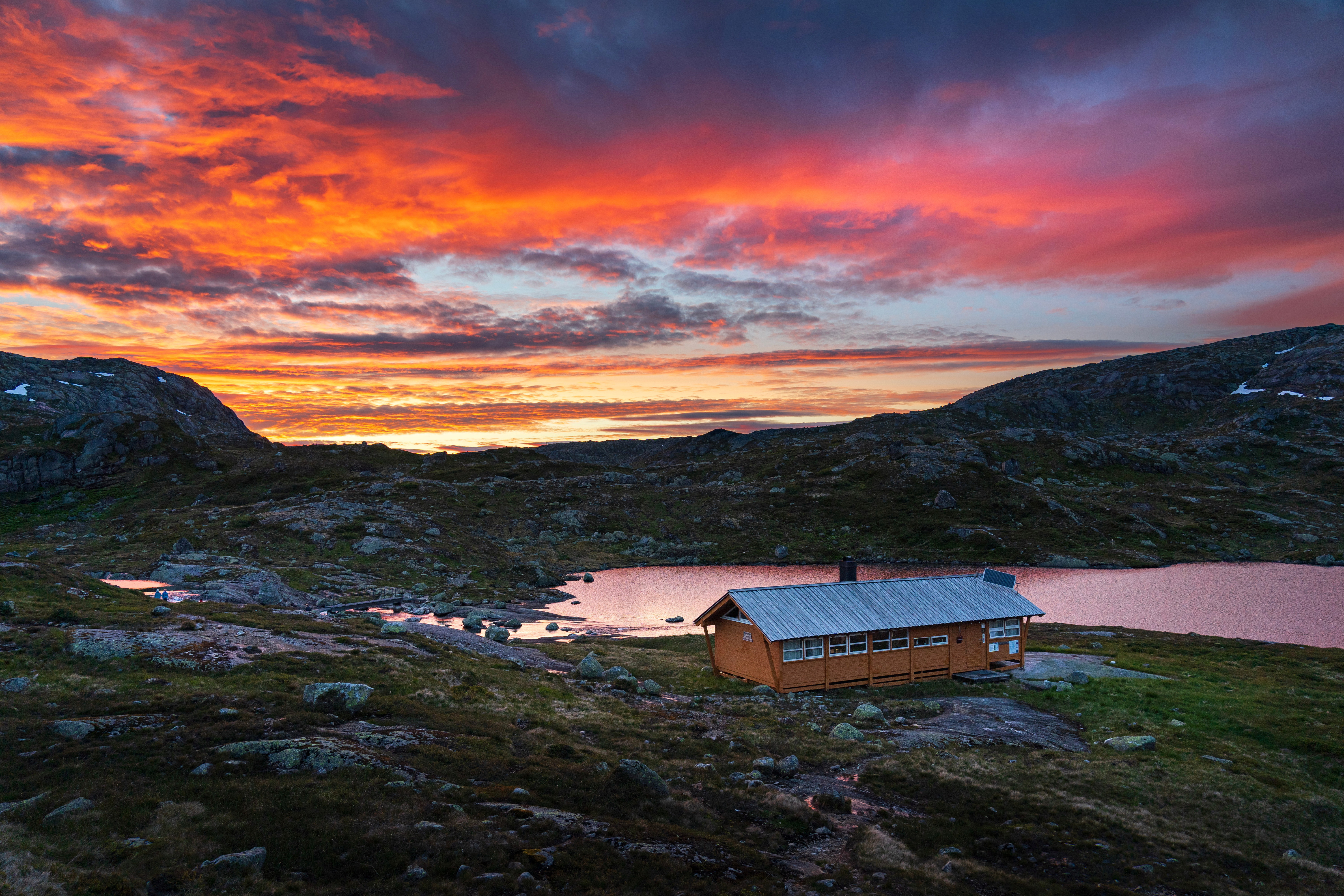 En gul hytte i solnedgang.