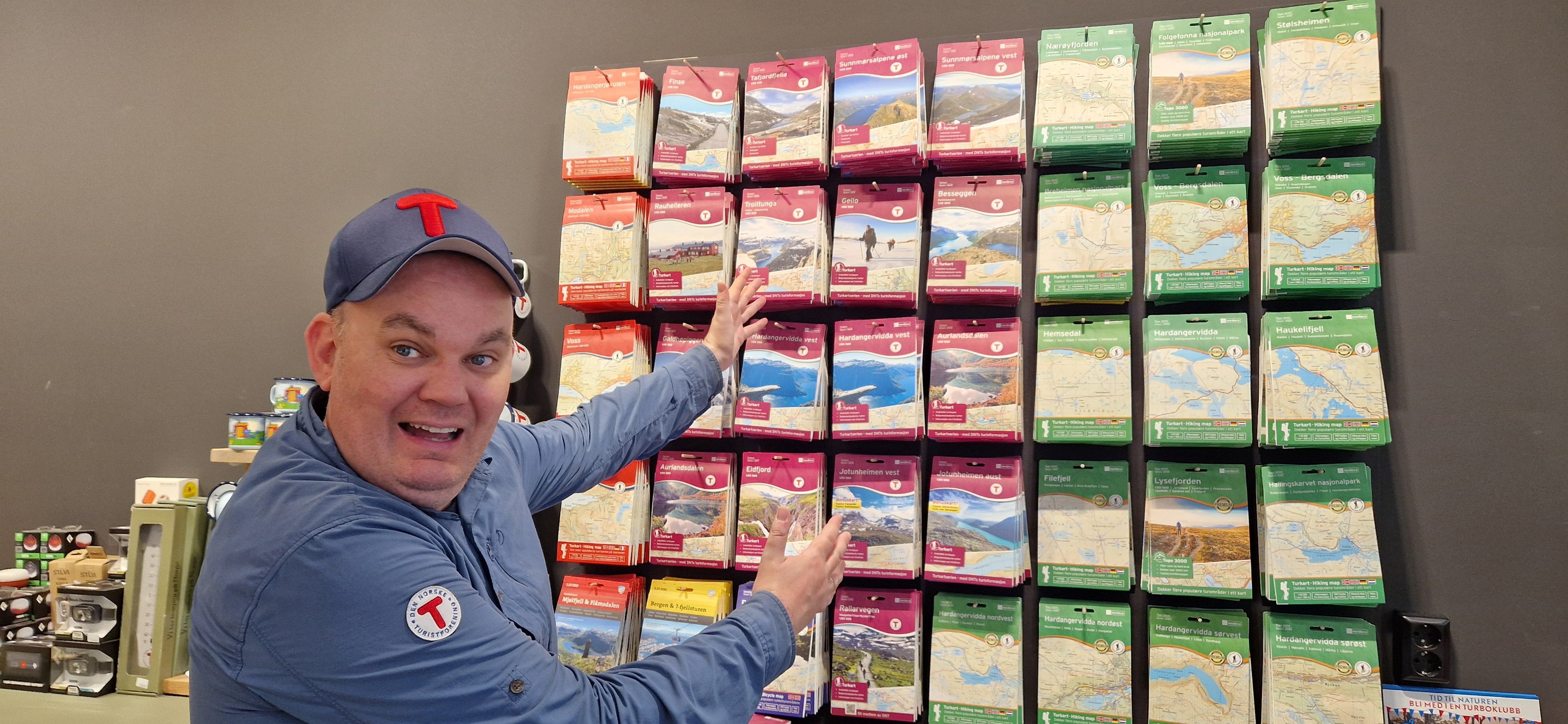 Mann med caps står foran og peker på vegg med kart