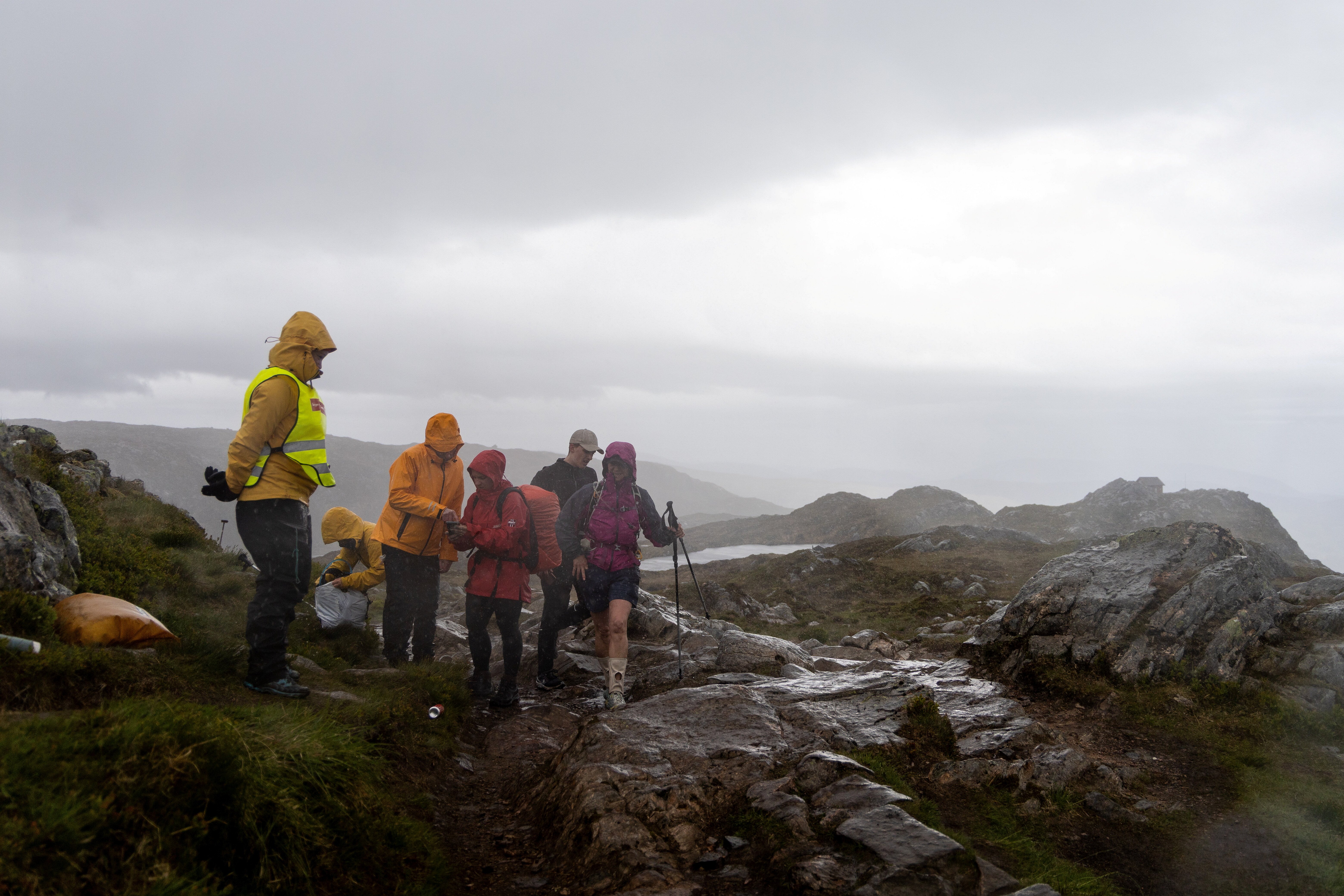 Flere personer i solide regnkl&aelig;r p&aring; fjellet