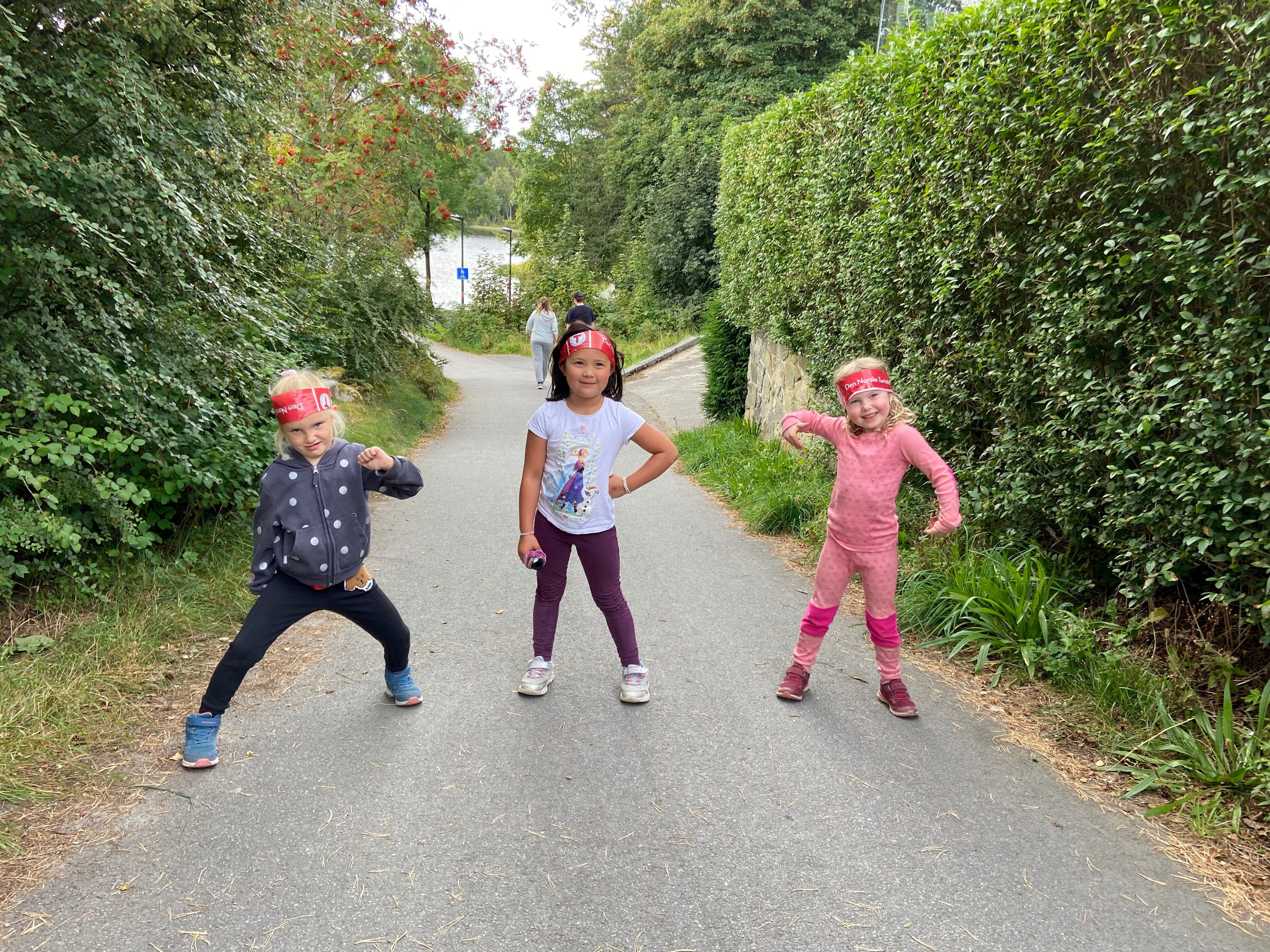 Tre barn lager morsomme uttrykk og gj&oslash;gler ute p&aring; tur