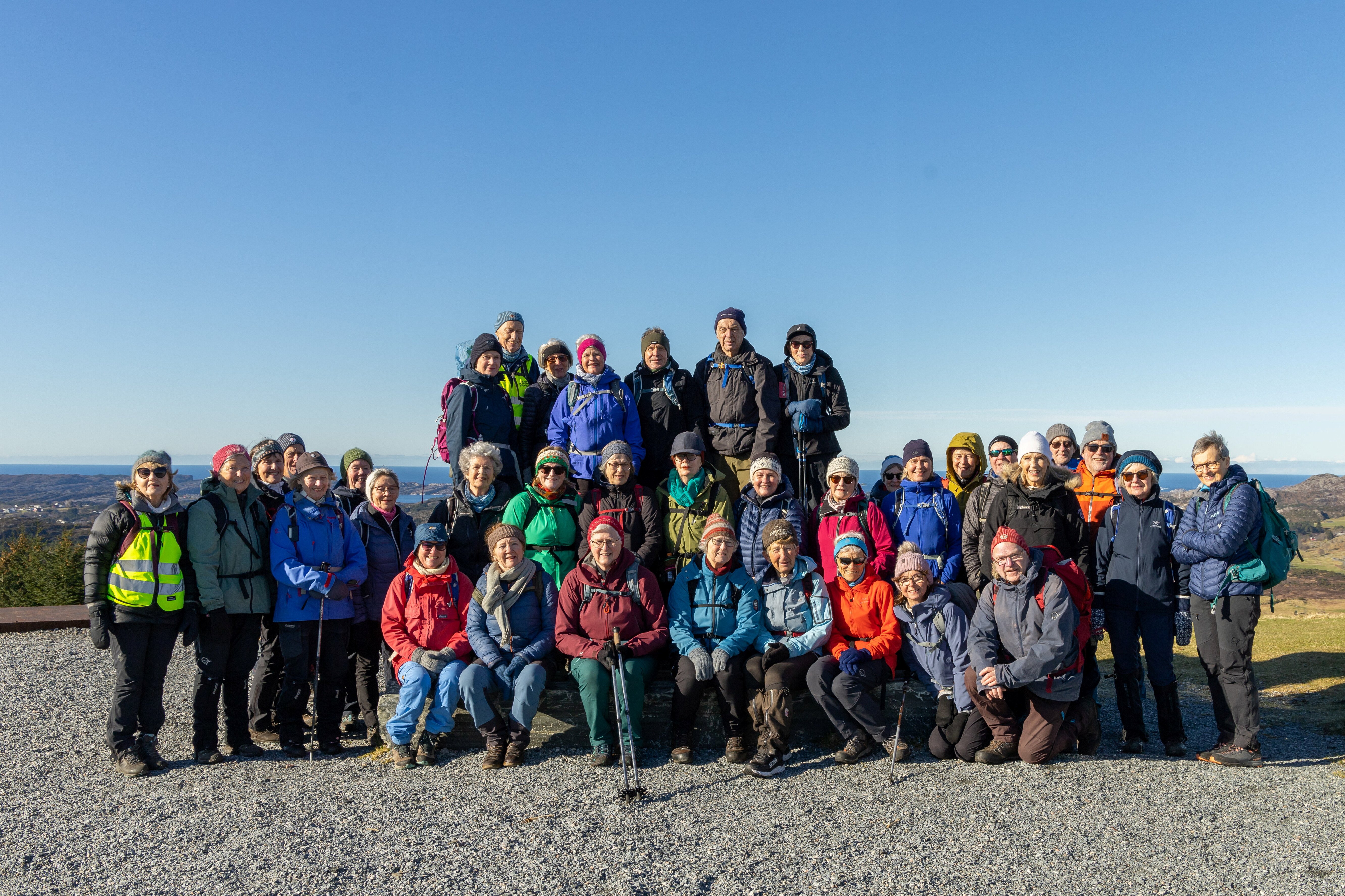 Gruppebilde av mange turkledde mennesker ute ved kysten.