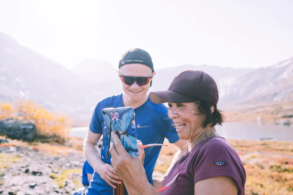 Kvinne tar selfie med turkamerat på fjellet.