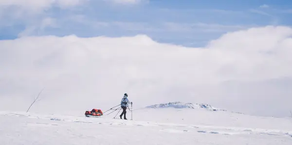 Skiløper med pulk i vinterfjellet