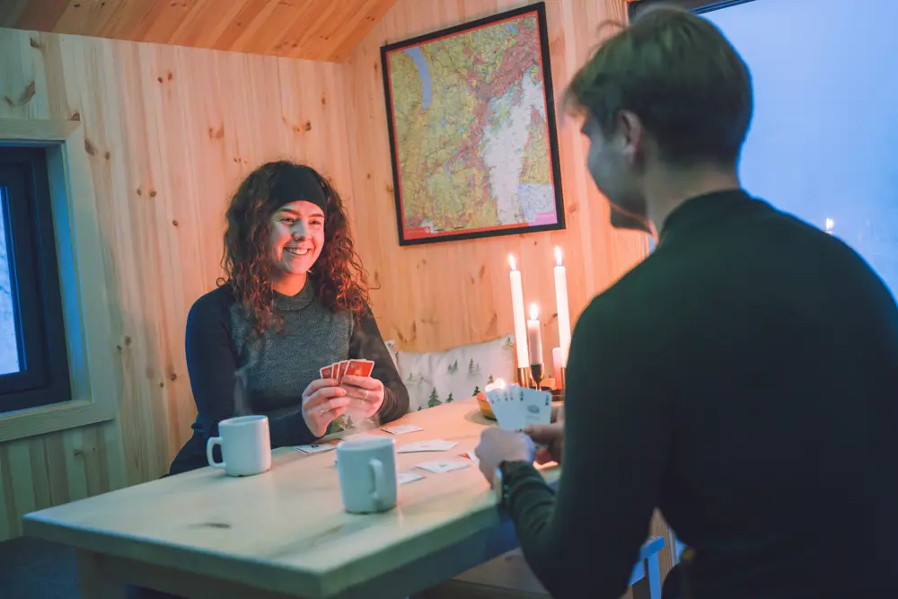 To personer spiller kort på dnt-hytte