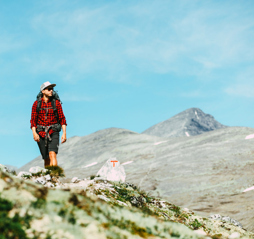 En person i shorts som går i fjellet