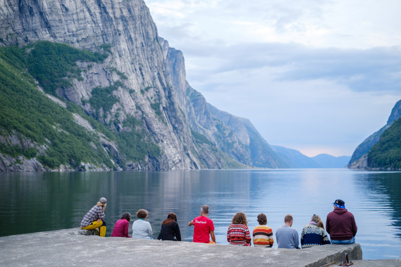 En gruppe mennesker speider utover en fjord