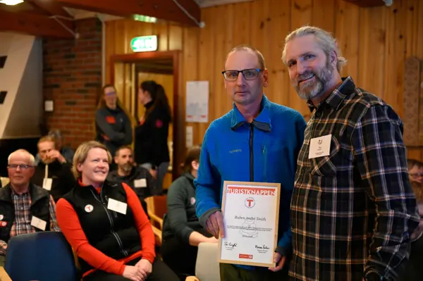 Ruben Andre Smith blir tildelt turistknappen i gull av styreleder i DNT Telemark, Thor Kamfjord.