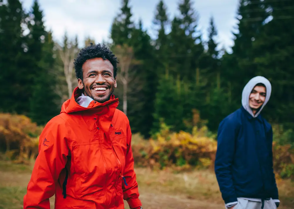 To smilende menn går tur i skogen