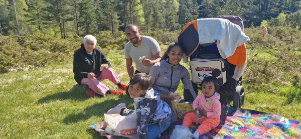 En colombiansk familie smiler i gresset.