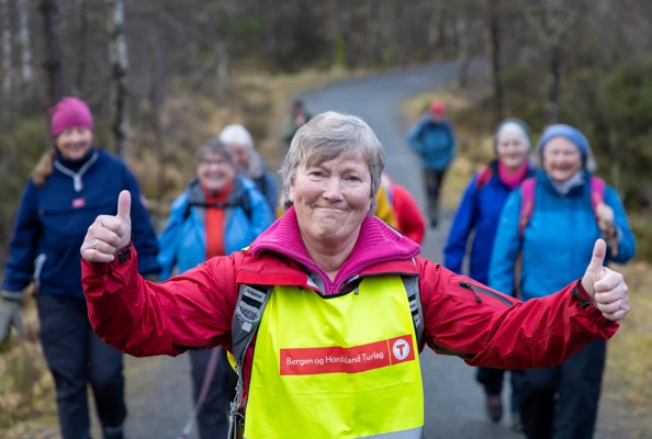En gruppe med turgåere sitter på et berg og spiser matpakkene sine med utsikt over Byfjellene.