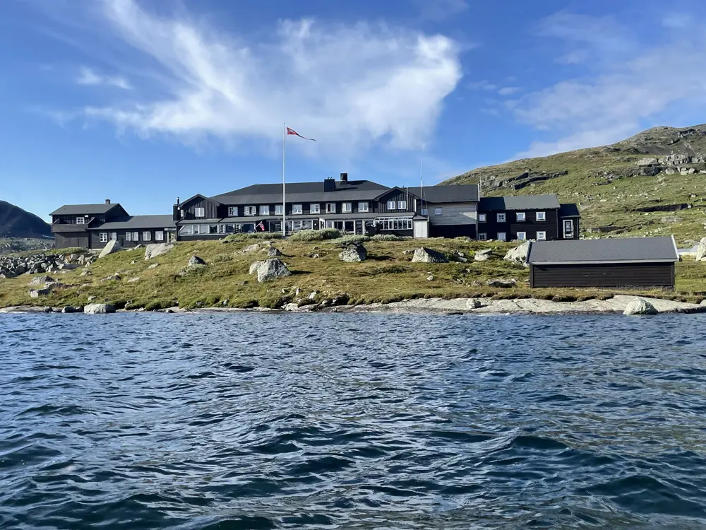 Svartmalt hytte i sommer sol. 