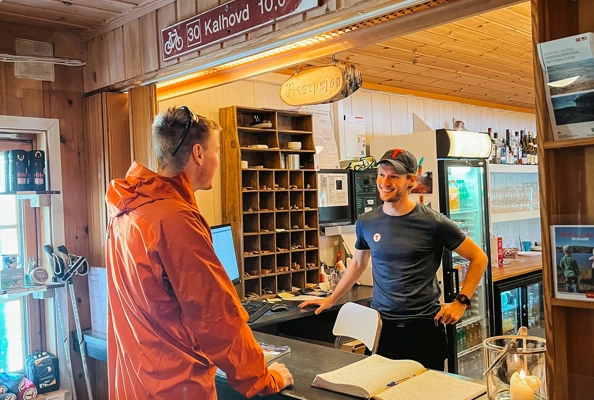 Rød hytte i snø på fjellet med portal.