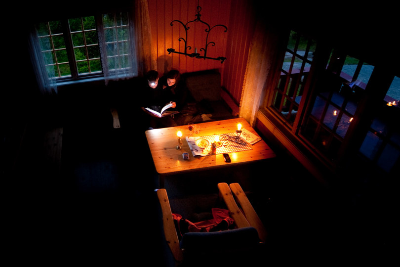 To personer som sitter i sofa og leser en bok sammen