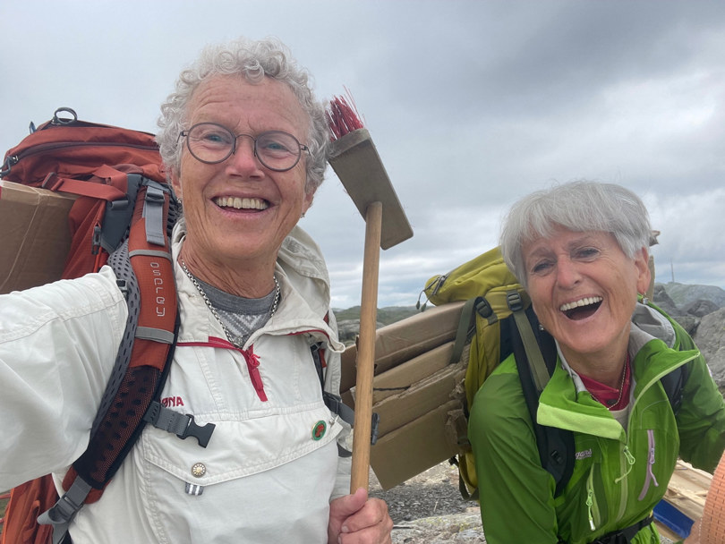 To kvinner smiler på fjellet