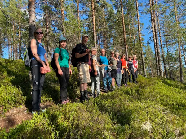 Mennesker står på rekke i skogen
