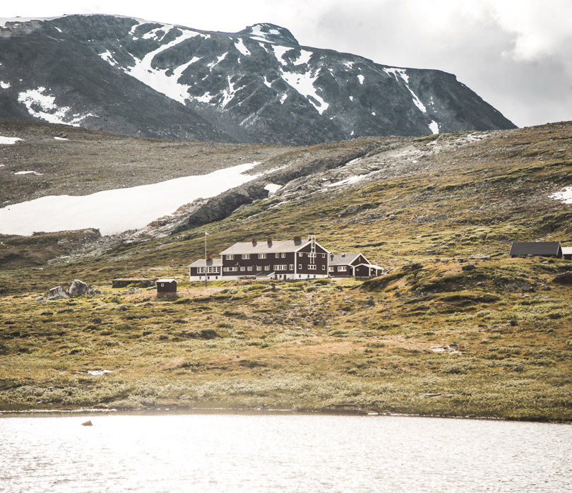 En svartmalt hytte som ligger i fjellet