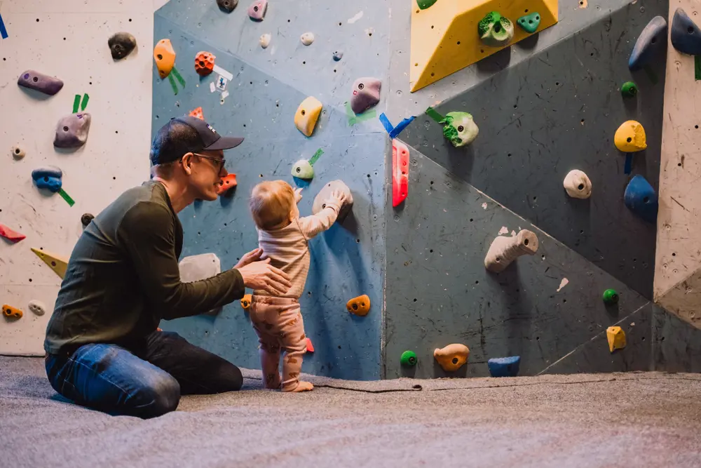 En mann og en baby som ser på en klatrevegg