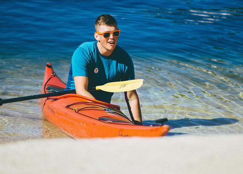 mann i kajakk på strand