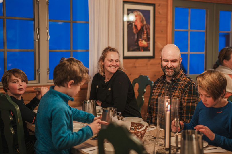 familie rundt et middagsbord på en betjent dnt-hytte