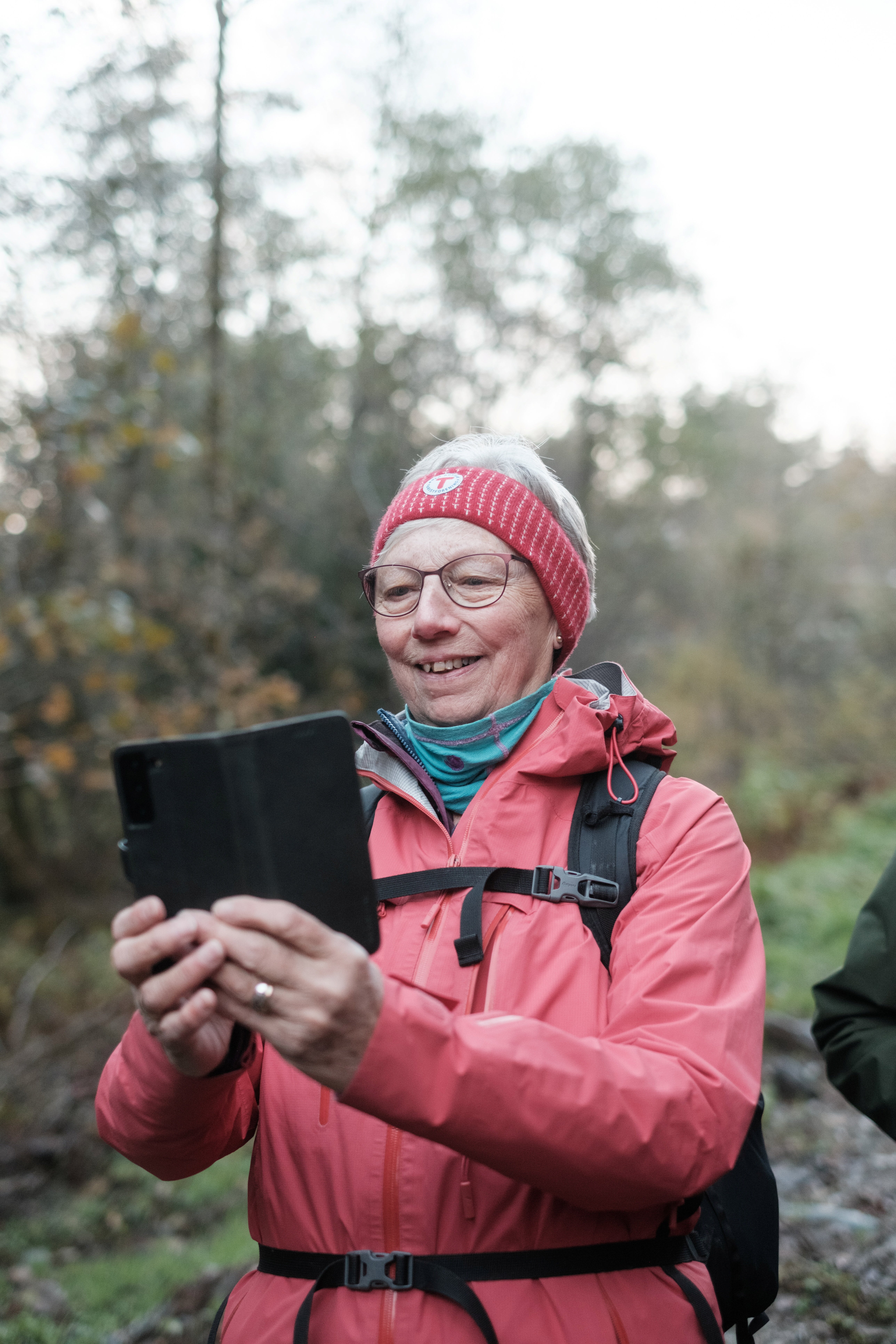 Kvinne kledt i turklede tar bilete med mobiltelefon.