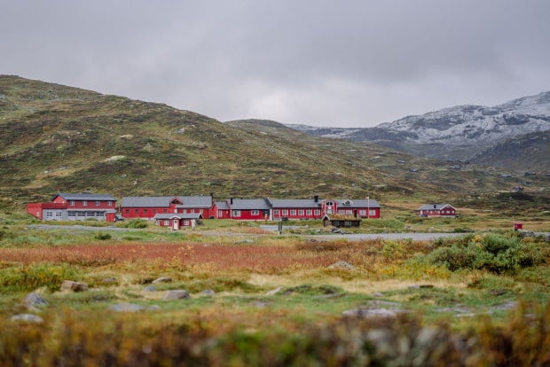 Bilde av stor r&oslash;d hytte i vakkert h&oslash;stfjell.
