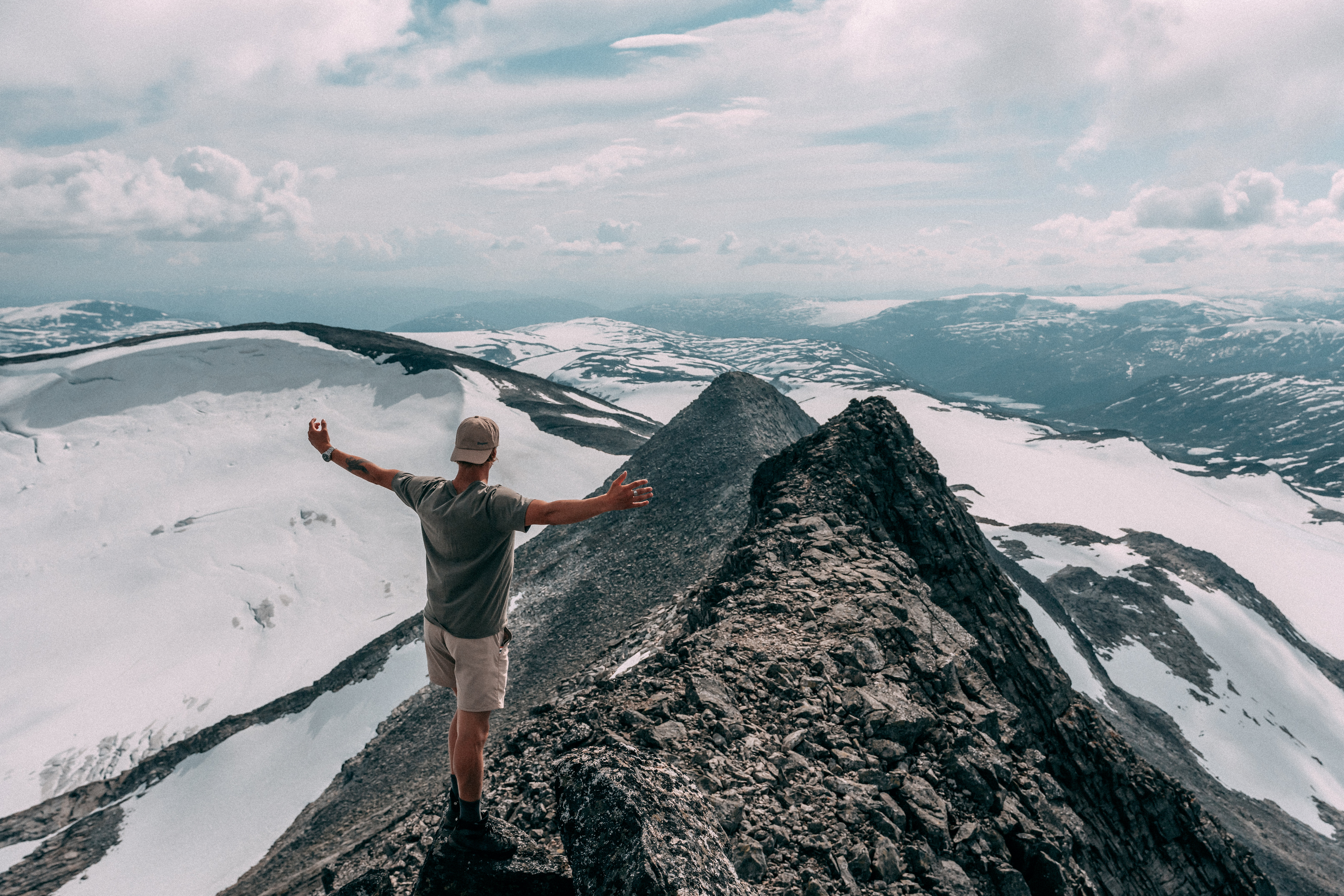 person som st&aring;r p&aring; en fjelltopp