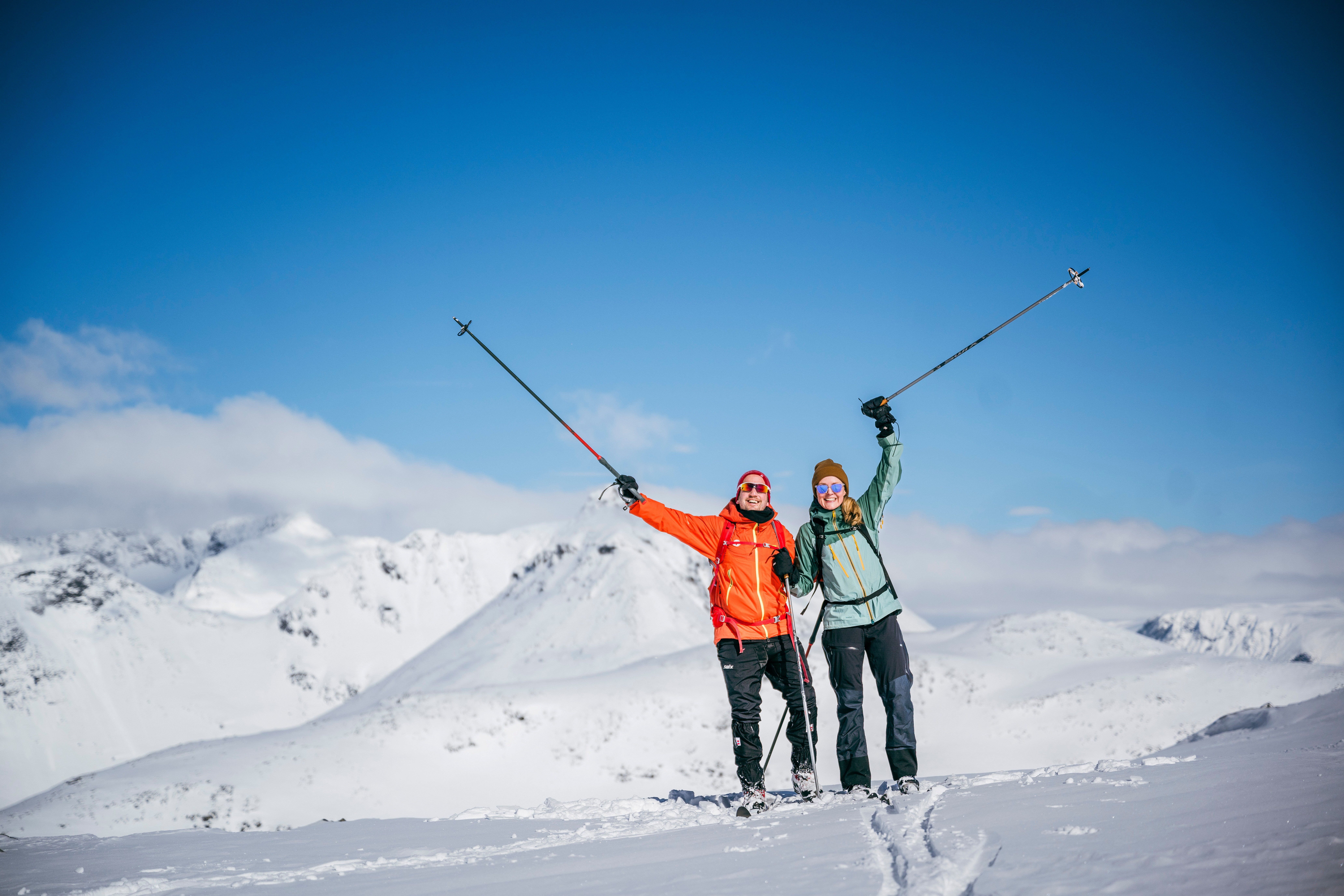 to personer p&aring; ski h&oslash;yt til fjells
