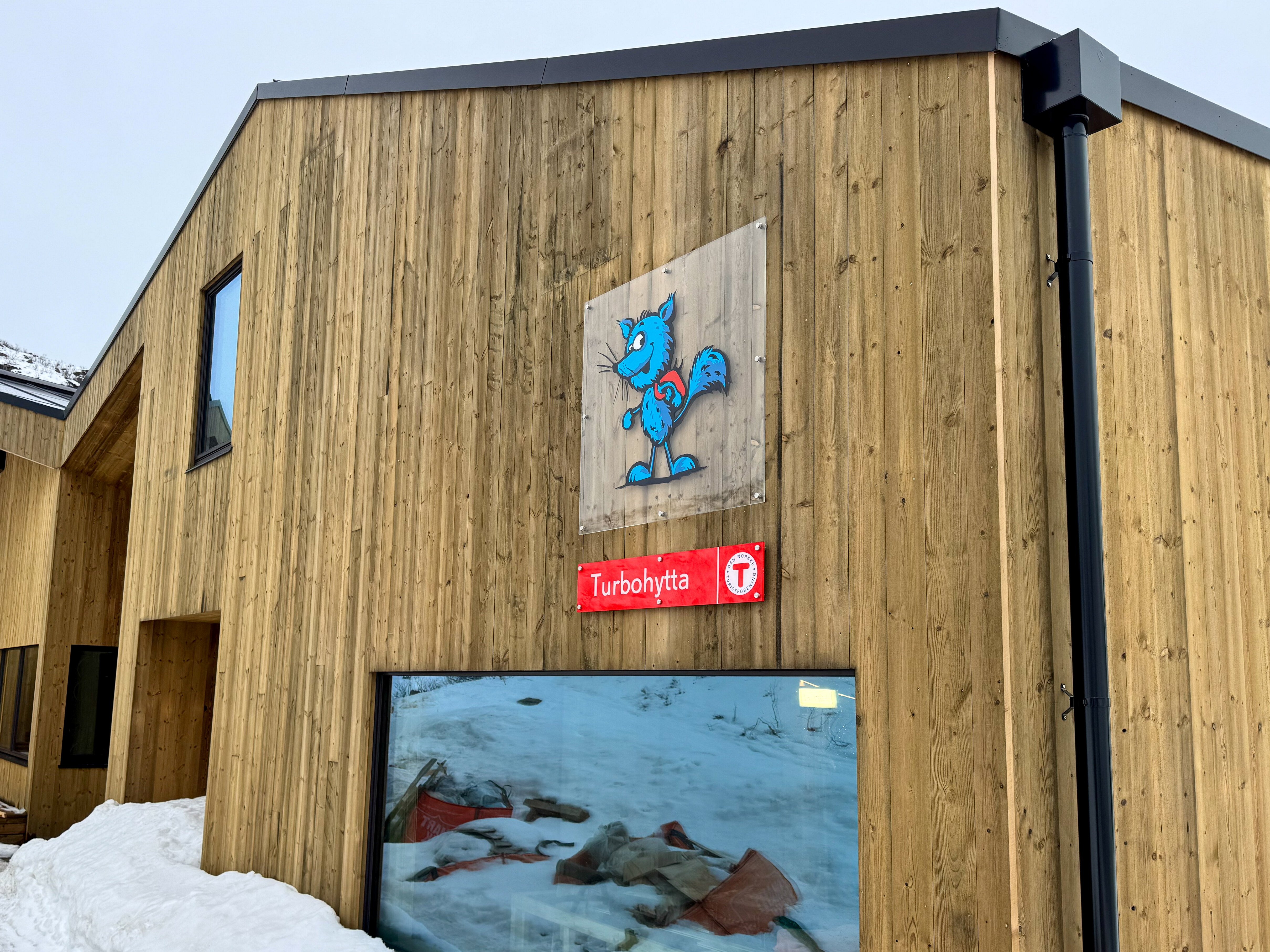 Bilde av en hytte med et skilt hvor det st&aring;r Turbohytta