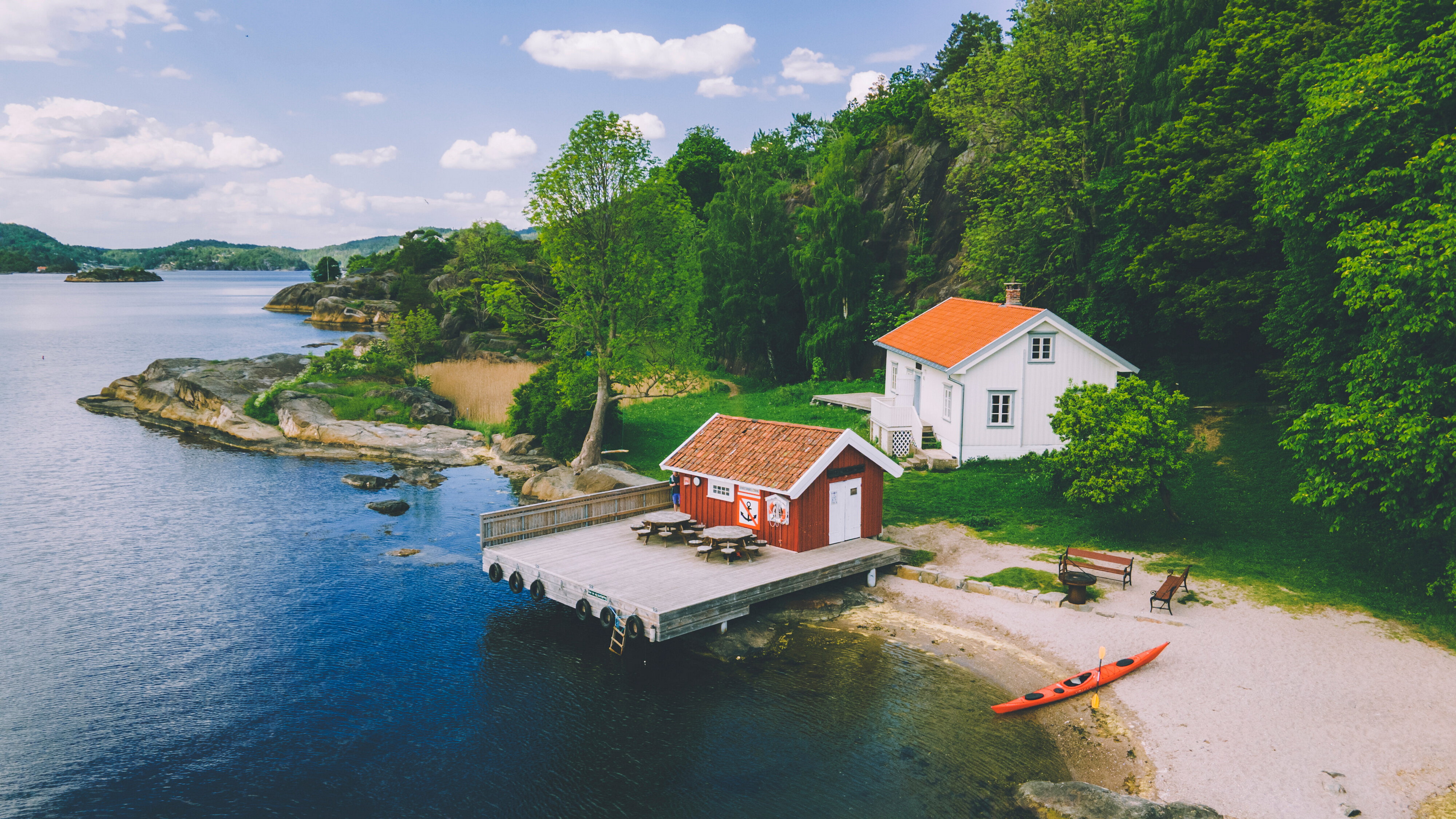 Hvit hytte ved brygge og strand i skikkelig kystidyll. Sildevika er en perle!