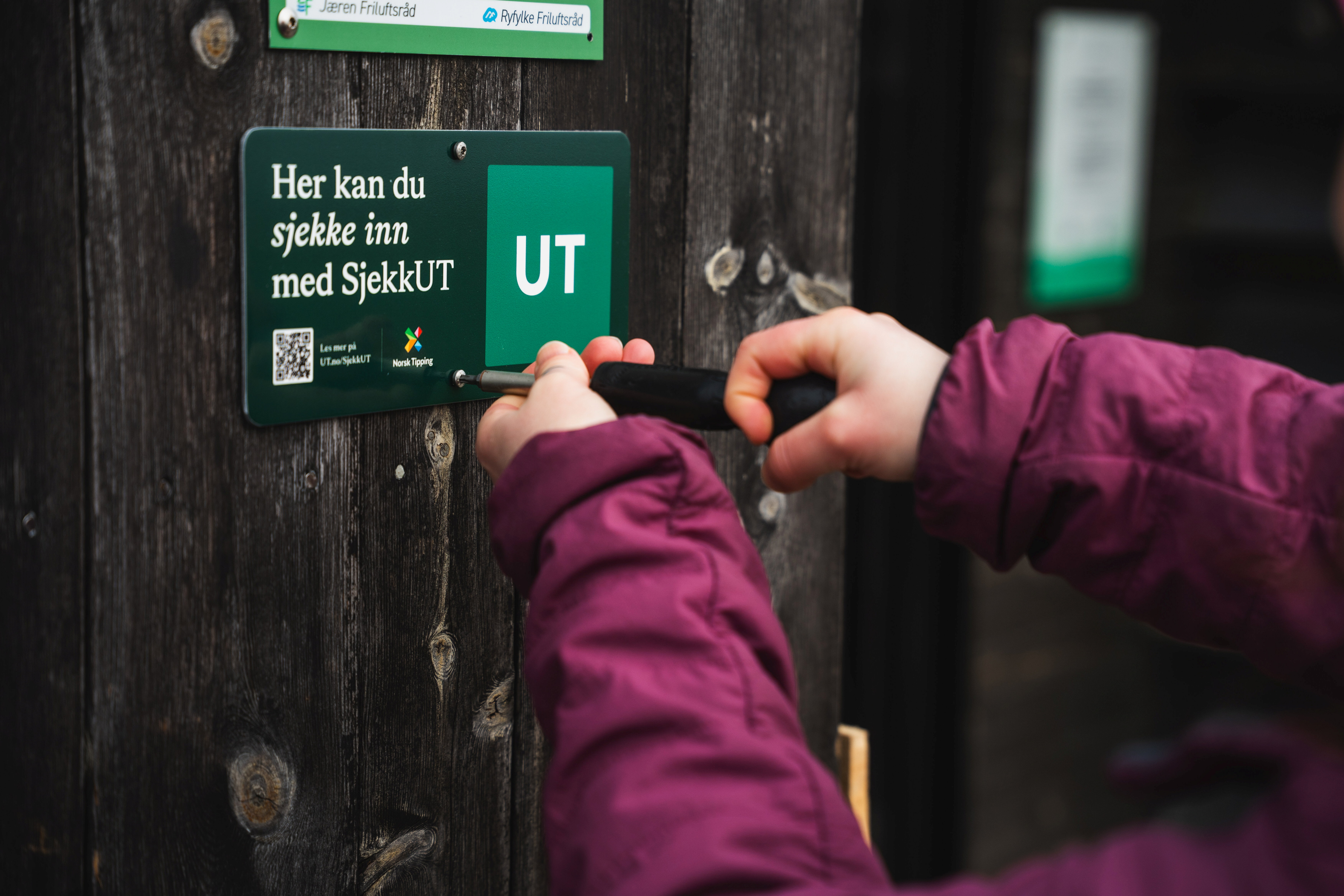 person som skrur opp skilt