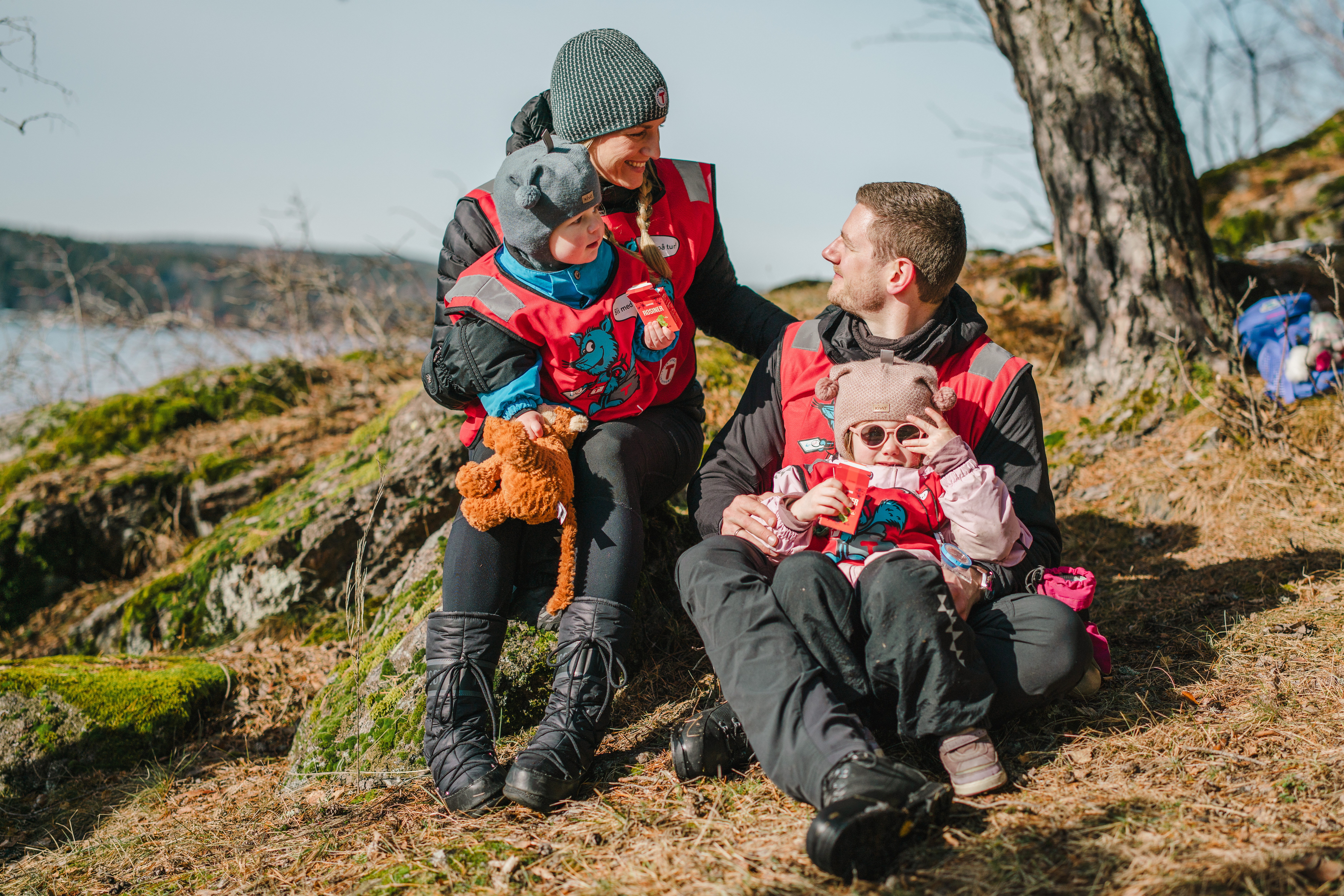 en familie som sitter under et tre langs kysten