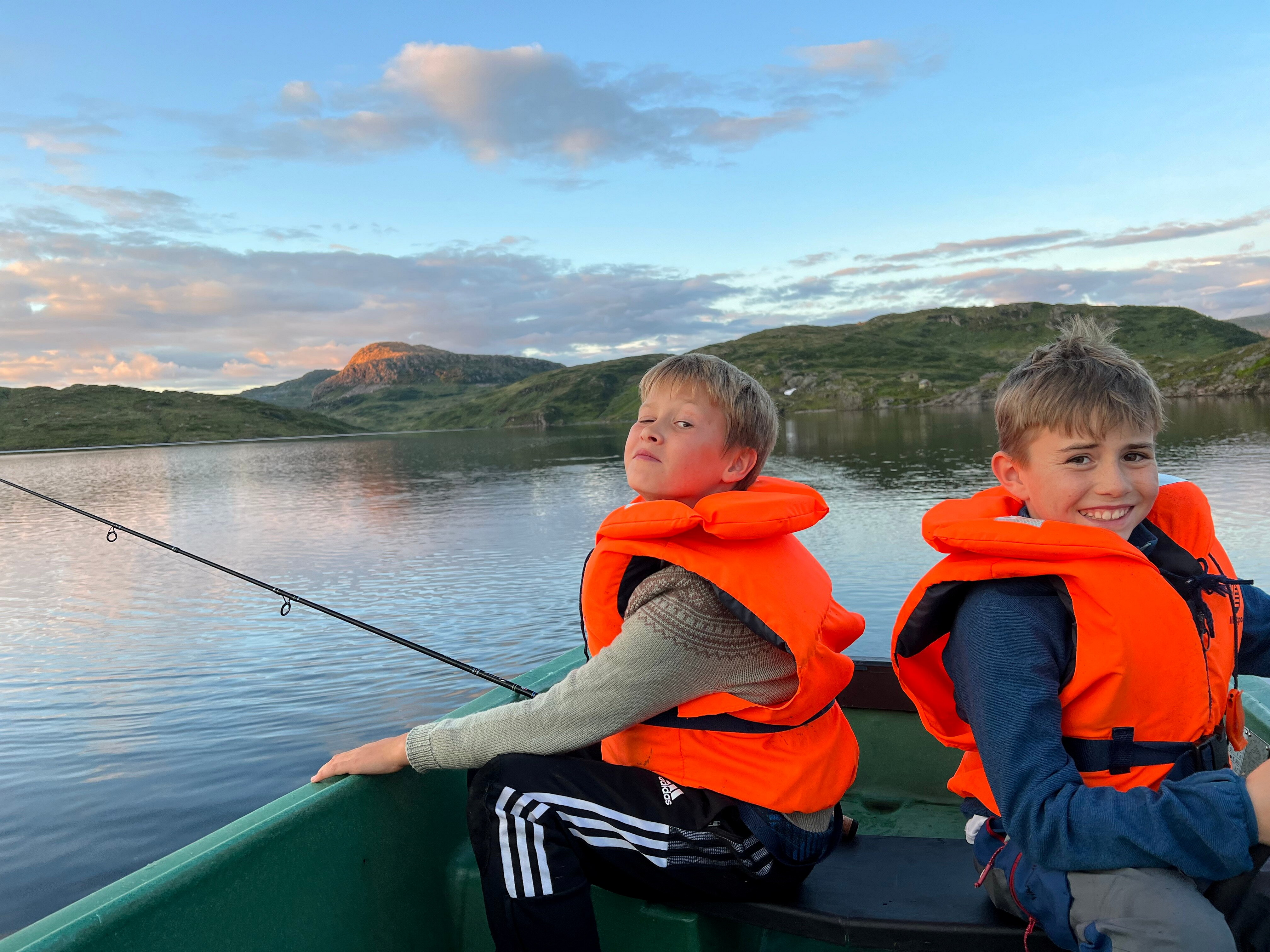 To gutter i b&aring;t med fiskestenger p&aring; Selhamar Turisthytte.