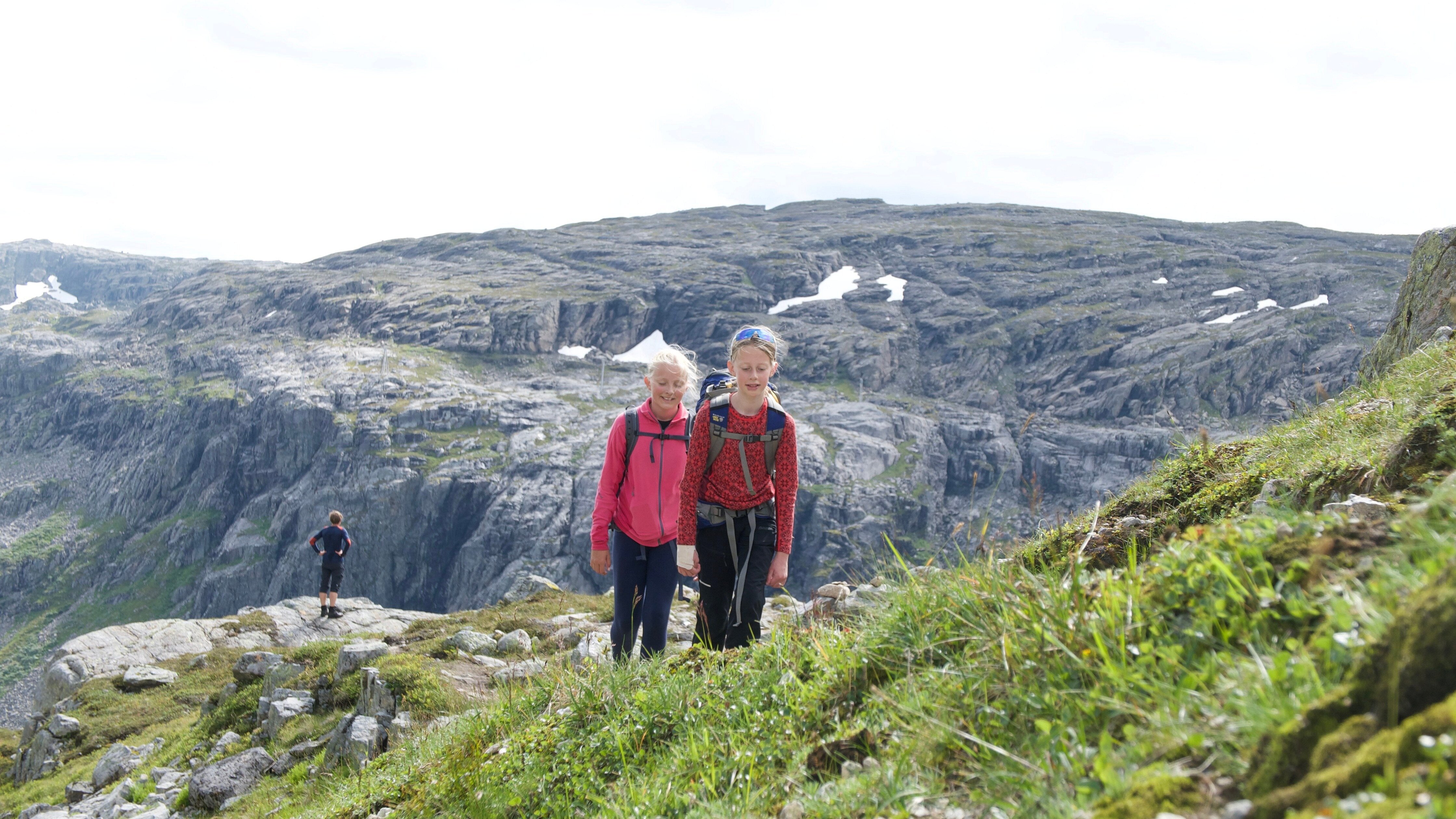 To jenter g&aring;r i bratt fjellterreng