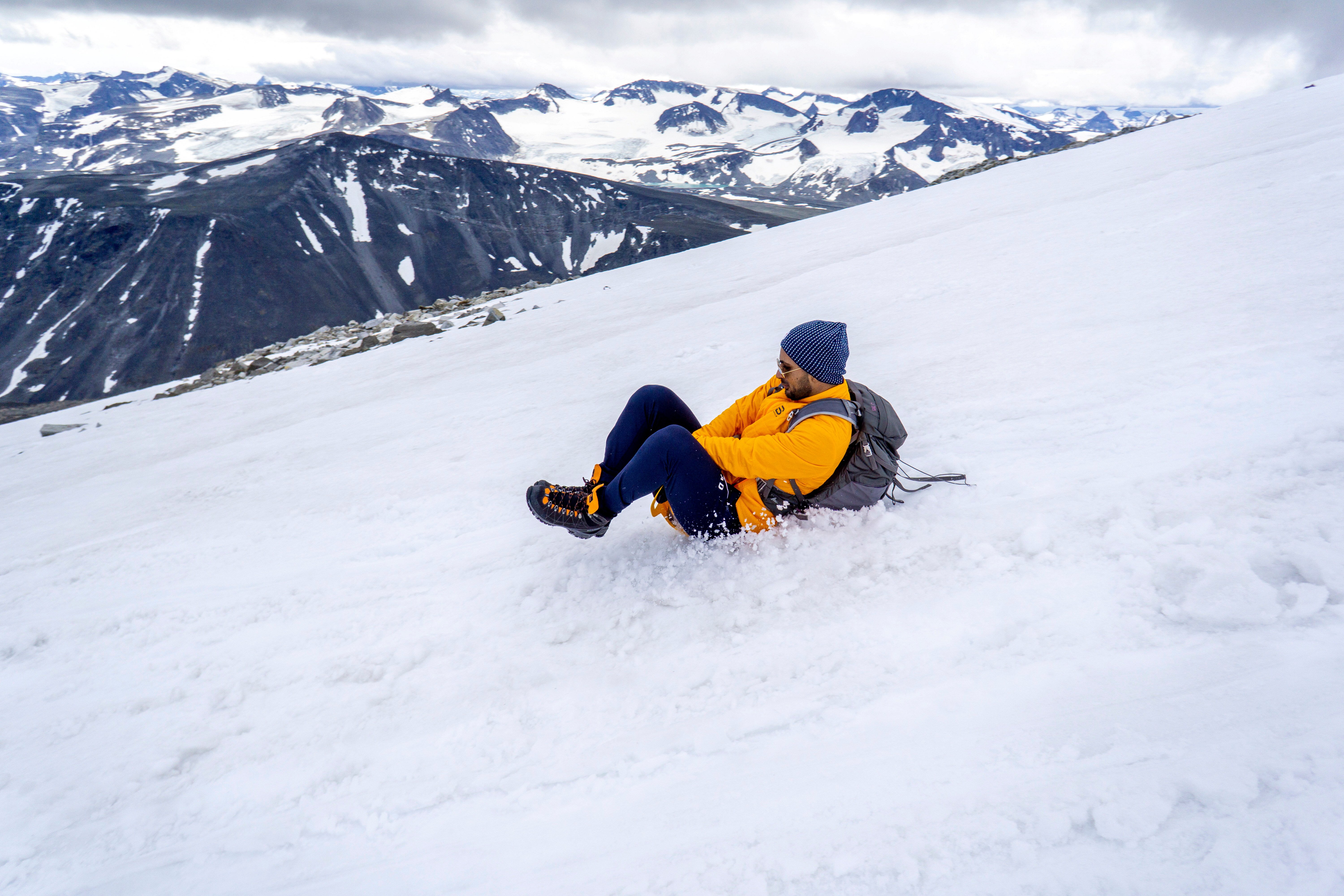 person som aker p&aring; en sn&oslash;fonn p&aring; et fjell
