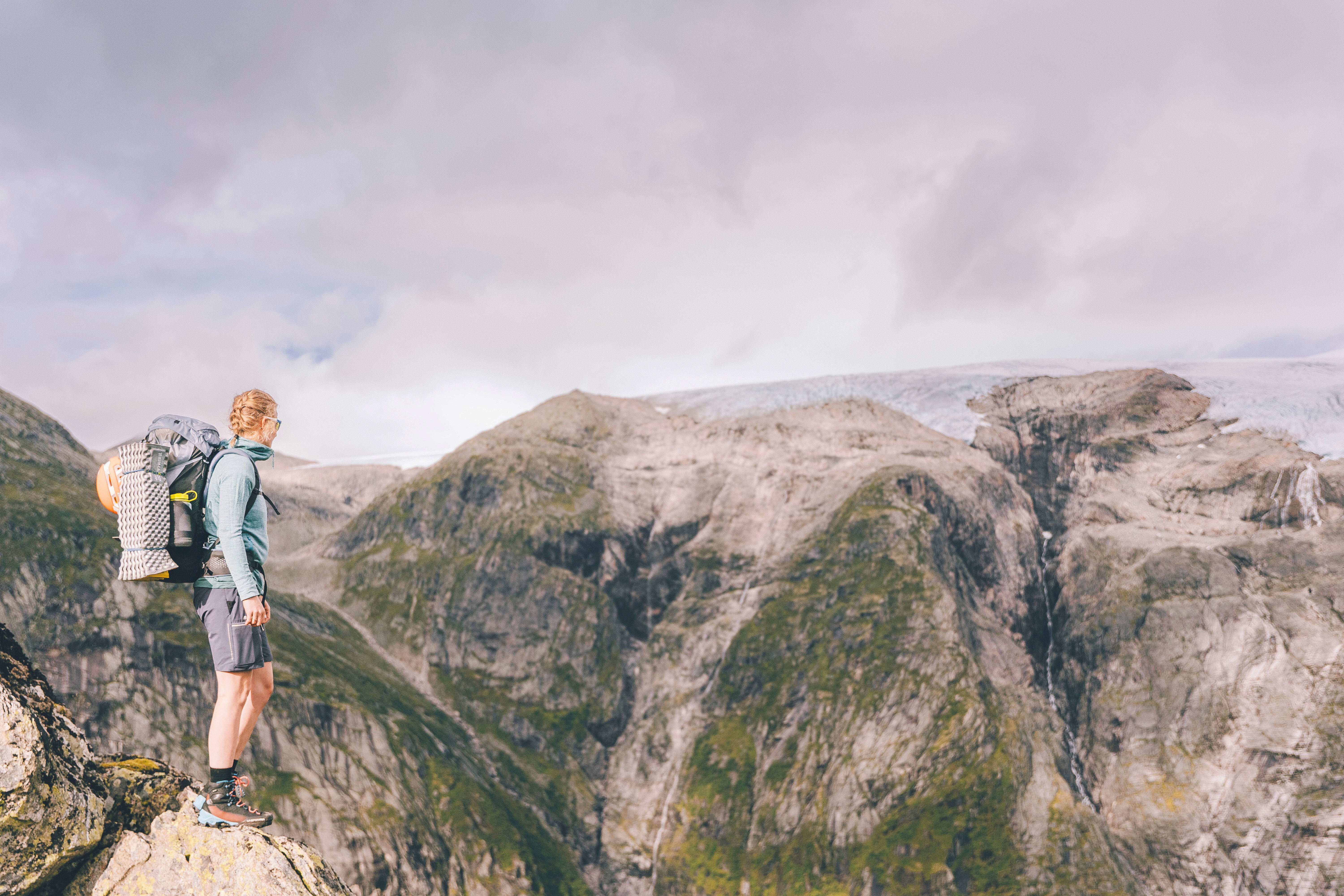 person som står i et fjellandskap og ser utover