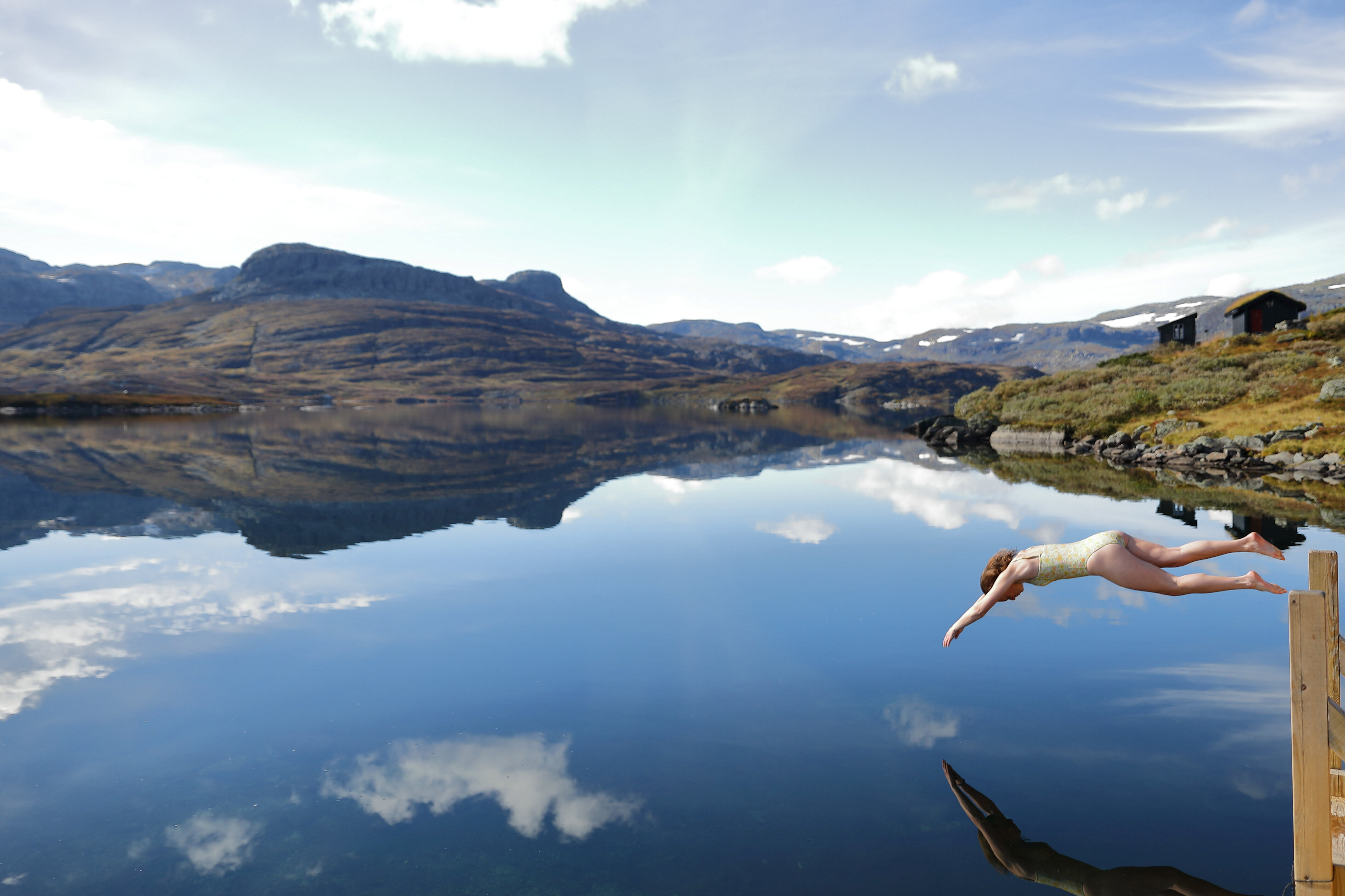 person som tar et stup ut i et fjellvann