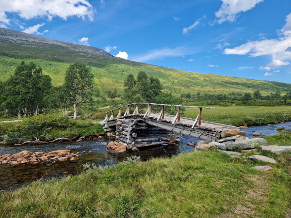 bilde av en trebru som g&aring;r over en fjellbekk